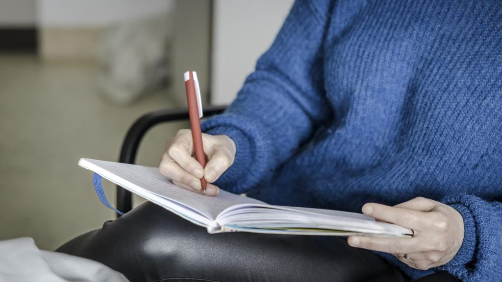 Een zorgverlener of vrijwilliger interviewt iemand die ongeneeslijk ziek is of door ouderdom aan het einde van het leven staat.