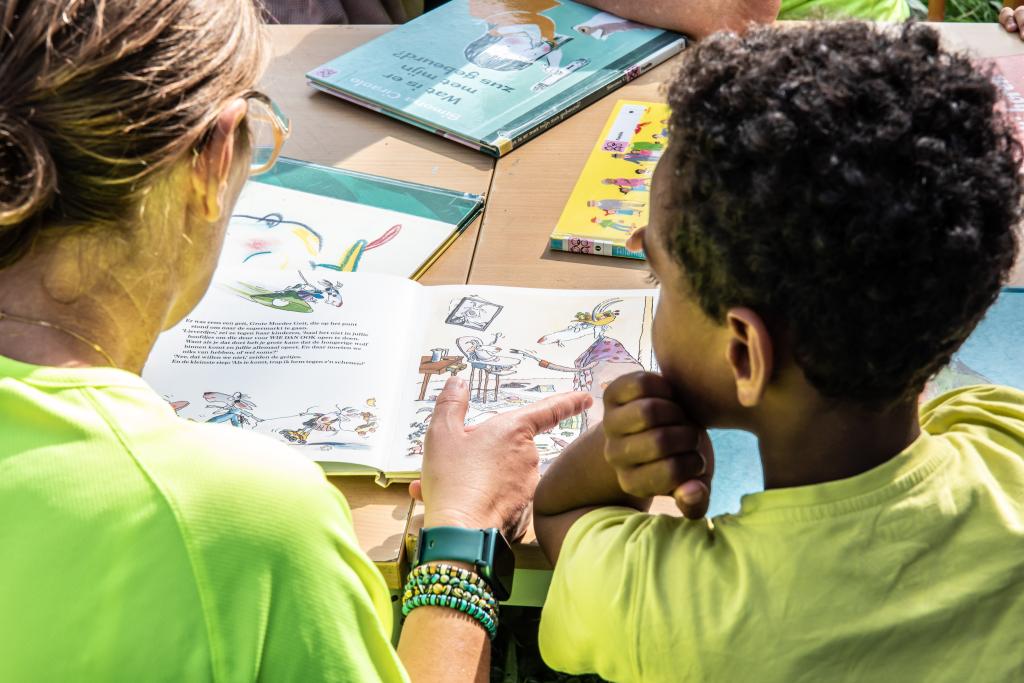 vrijwilliger en kind lezen samen in een boek - copyright Simon Bequoye/Iedereen Leest