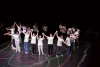 A group of teenagers from the Inside project on stage, saluting after their performance
